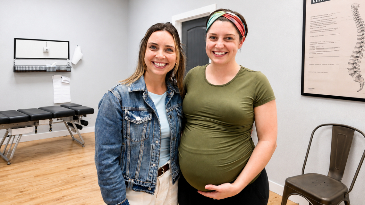 An expecting mother with her chiropractor in a treatment room at Abide Chiropractic in Fayetteville, AR